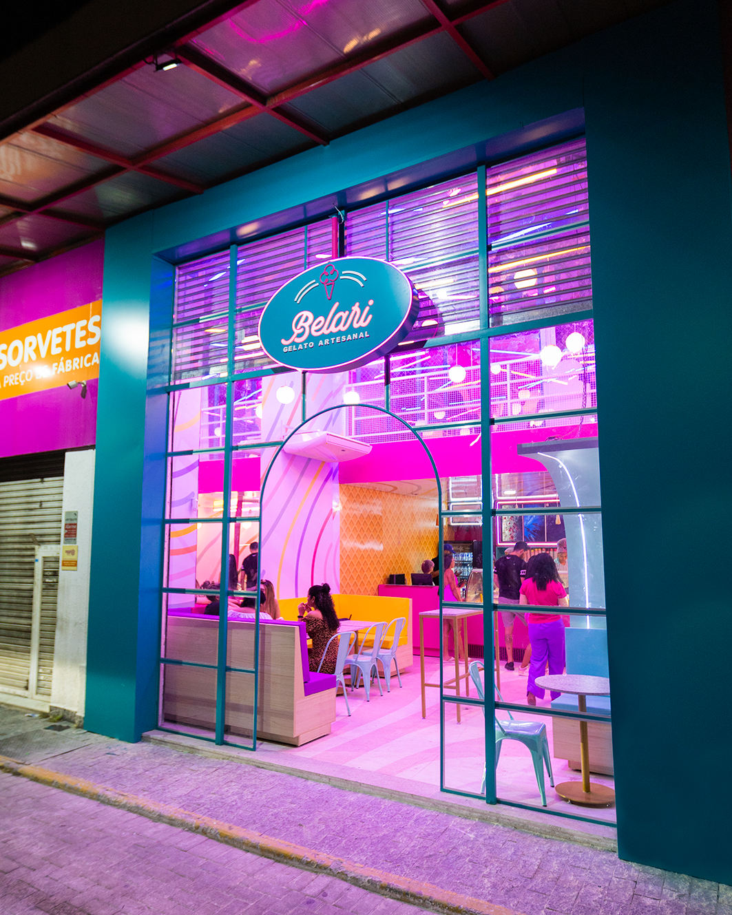 Fachada noturna da loja Belari com iluminação neon